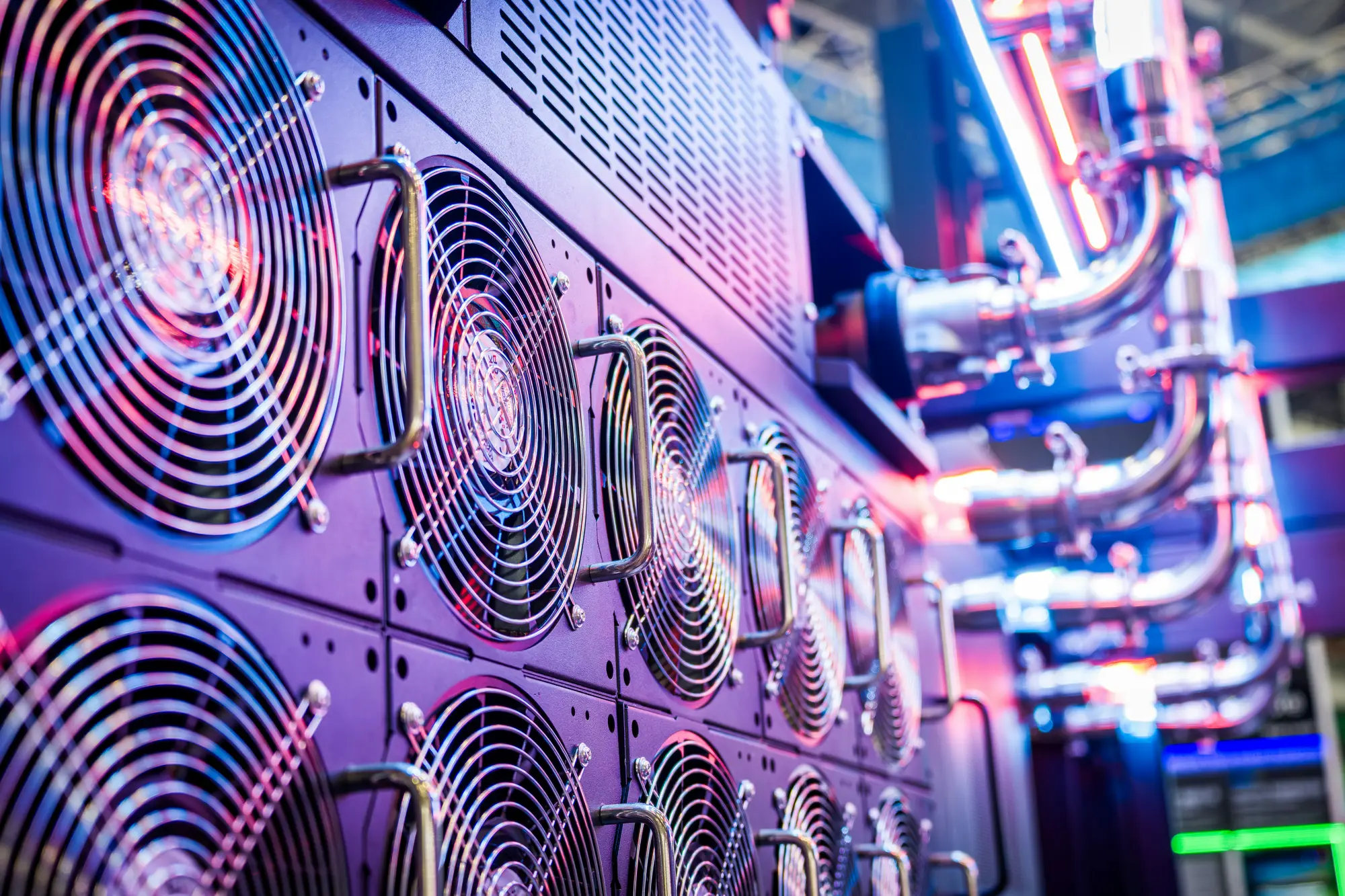 A close-up of illuminated server cooling fans and cabling inside a data centre.